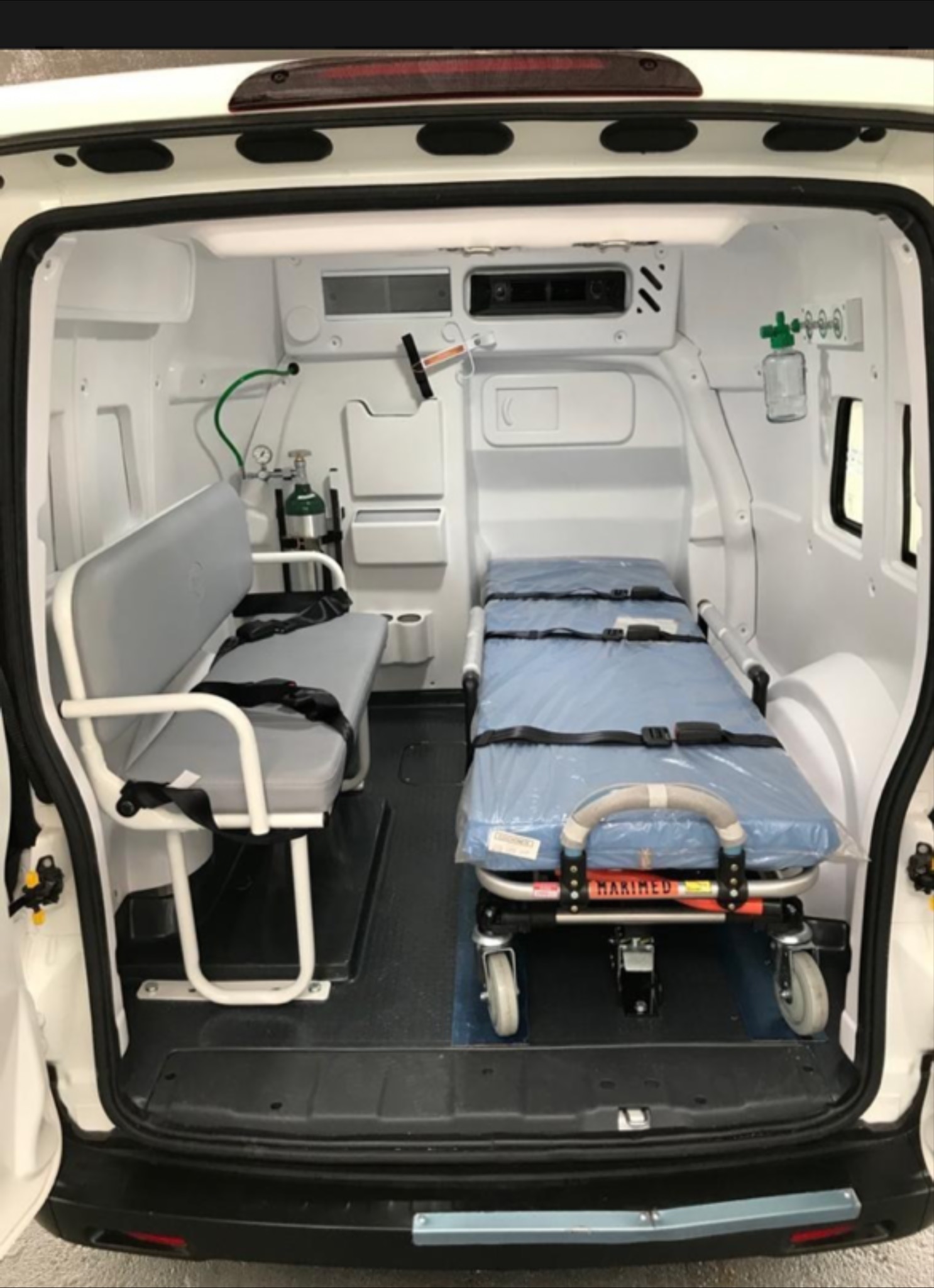 Interior de ambulancia basica com maca e banco lateral